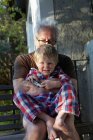 Старший мужчина обнимает внука на улице — стоковое фото