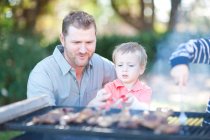 Father and sons barbecuing — Stock Photo