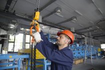 Male worker checking cables in industrial plant — Stock Photo