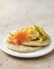 Smoked salmon and scrambled egg on blini with chive garnish — Stock Photo