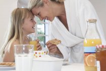 Mother and daughter having breakfast indoors — Stock Photo