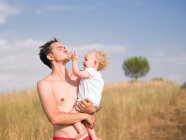 Mann trägt Sohn ins Freie — Stockfoto
