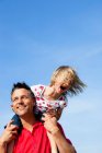 Girl Sitting On Fathers Shoulders — Stock Photo