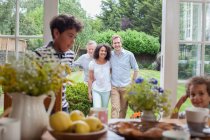 Family coming in for breakfast after walk in garden — Stock Photo