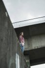 Junge Frau steht auf Mauer, niedriger Winkel — Stockfoto