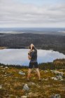 Man stretching on rocky cliff top, Keimiotunturi, Lapland, Finlândia — Fotografia de Stock