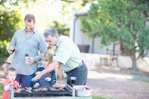 Male family members barbecuing — Stock Photo