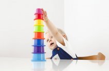 Niño jugando con tazas de apilamiento - foto de stock