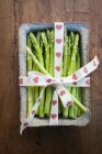 Tub of fresh asparagus tied with ribbon — Stock Photo