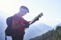Mountain biker holding map, Valais, Switzerland — Stock Photo