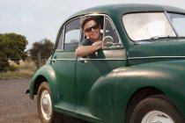 Portrait of young man in vintage morris minor — Stock Photo