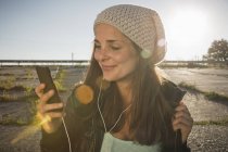 Молода жінка в навушниках слухає музику — стокове фото