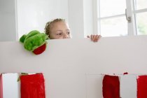 Дівчина дивиться над іграшковим театром з маріонеткою — стокове фото