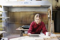 Junge Handwerkerin nutzt digitales Tablet in Orgelwerkstatt — Stockfoto