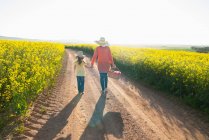 Mother and daughter walking on dirt road — Stock Photo