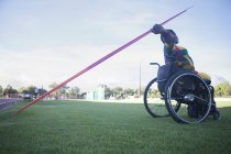 Зріла жінка в інвалідному візку кидає списа — стокове фото