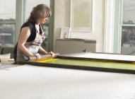 Frau bedruckt Textilien von Hand in Werkstatt — Stockfoto