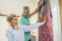 Senior couple making decision on wallpaper — Stock Photo
