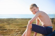 Мальчик сидит на пляже — стоковое фото