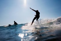 Dois homens a surfar na baía de Constantine à luz do sol — Fotografia de Stock