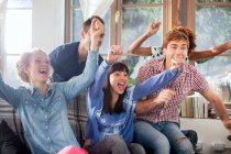 Groupe d'amis regardant la télévision applaudir — Photo de stock
