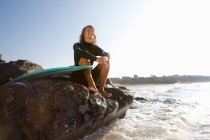 Donna seduta su grandi rocce — Foto stock