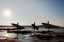 Tre persone con tavole da surf in piedi — Foto stock