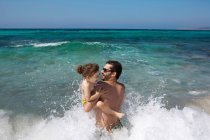 Pai e filha brincando em ondas — Fotografia de Stock