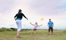 Família brincando com disco voador ao ar livre — Fotografia de Stock