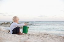 Petit garçon jouant avec le sable sur la plage — Photo de stock