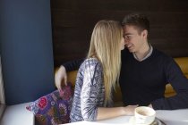 Romántica pareja joven cara a cara en la cafetería - foto de stock