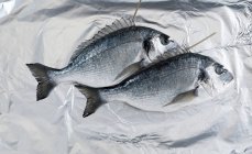 Укладка рыбы на алюминиевой фольге — стоковое фото