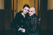 Porträt eines jungen lesbischen Paares, das sich im Hausflur umarmt — Stockfoto