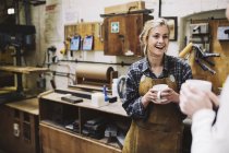 Zwei junge Handwerkerinnen plaudern in Pfeifenorgelwerkstatt — Stockfoto