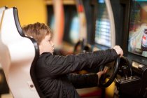 Boy playing on driving video game — Stock Photo
