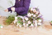 Femme organiser des roses dans les fleuristes — Photo de stock