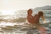 Mãe e filha brincando no oceano — Fotografia de Stock