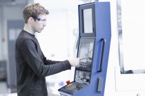 Técnico macho adulto médio mantendo a máquina na planta de engenharia — Fotografia de Stock