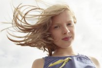 Portrait of girl with flyaway hair at breezy coast — Stock Photo