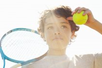 Крупним планом хлопчик з тенісною ракеткою і м'ячем — стокове фото