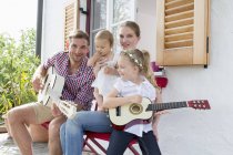 Pai tocando guitarra com a família — Fotografia de Stock
