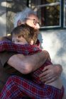 Літній чоловік обіймає онука на відкритому повітрі — стокове фото