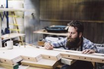 Обрізаний знімок серед дорослих майстрів, що вимірюють компонент деревини в органній майстерні — стокове фото