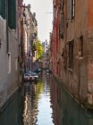 Buildings and rowboats on urban canal — Stock Photo