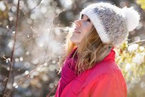 Молода доросла жінка серед гілок покритих снігом дерев — стокове фото