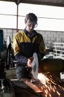 Trabalhador de metal usando moedor na loja — Fotografia de Stock
