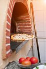 Pizza pulling from oven — Stock Photo