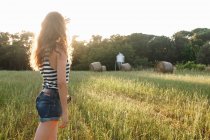 Жінка стоїть у трав'янистому полі — стокове фото