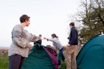Menschen schlagen Zelte auf Zeltplatz auf — Stockfoto