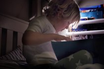 Мальчик читает на кровати — стоковое фото